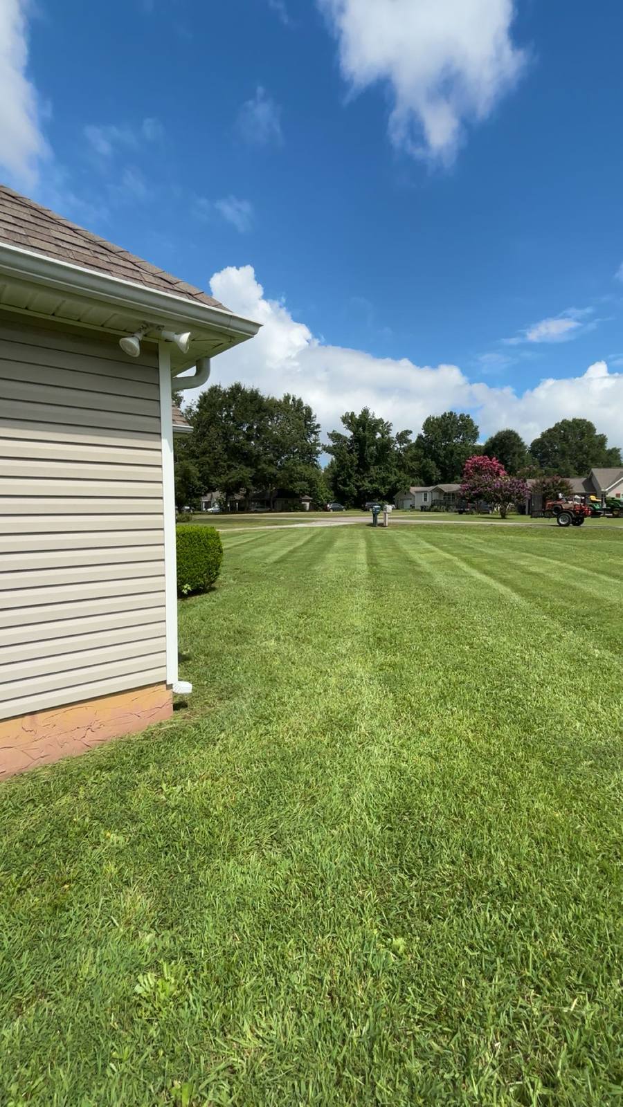 Freshly mowed lawn with crisp mowing stripes running out to a neighborhood street